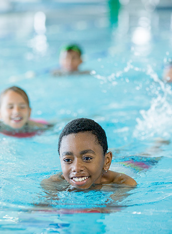 A group of children are in the water exercising. 